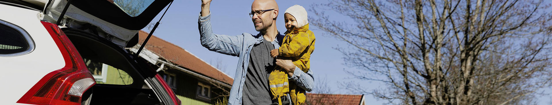 pappa och barn vid sin bil