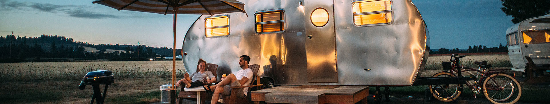 par sitter utanför sin husvagn