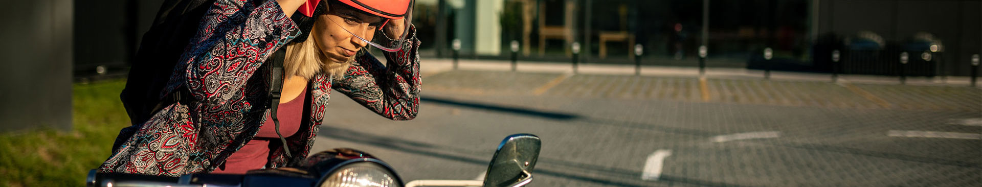 ung tjej med röd hjälm vid sin moped