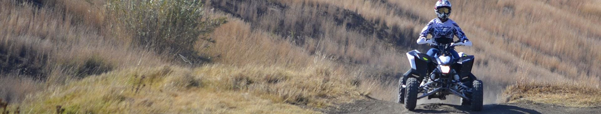 ung person kör en fyrhjuling i terräng