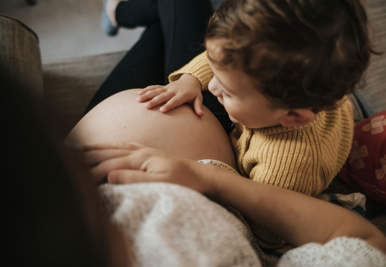 Pojke klappar på sin mammas gravida mage