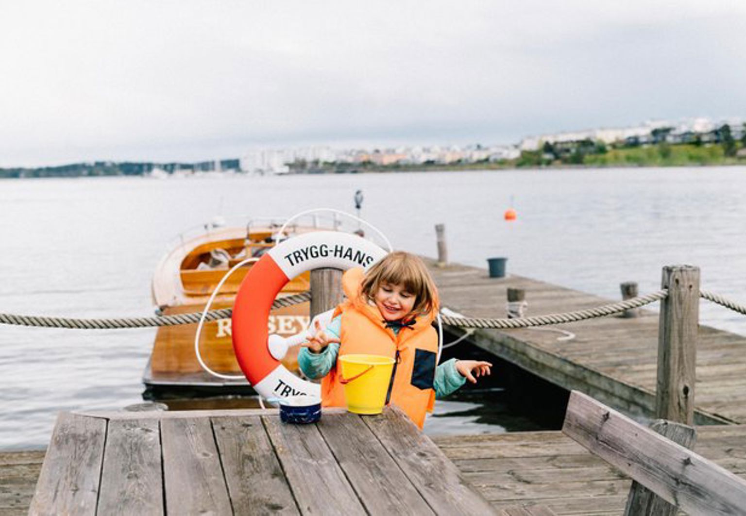 Flicka leker på en brygga