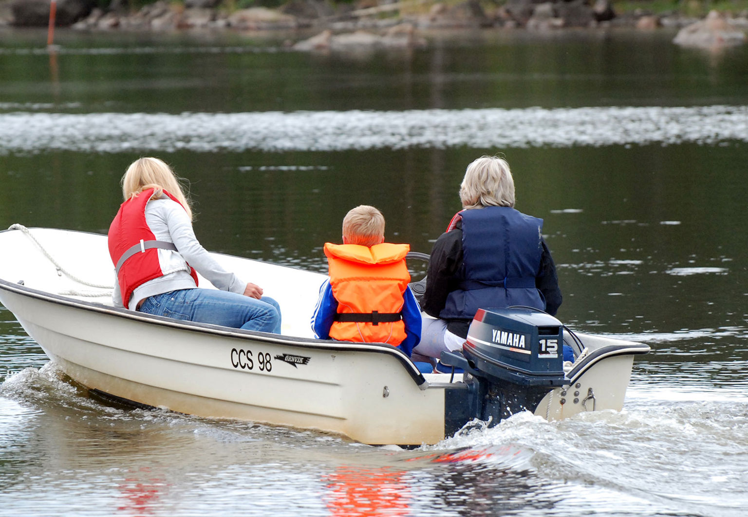 Familj på utflykt i liten motorbåt
