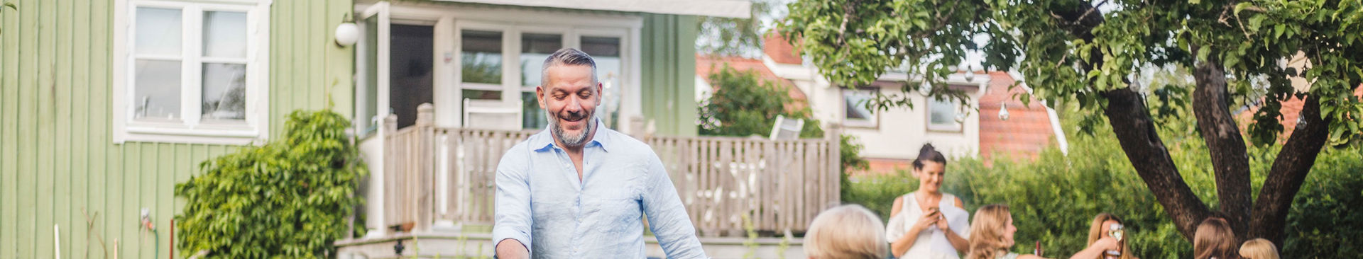 man och pojke spelar fotboll utanför villa