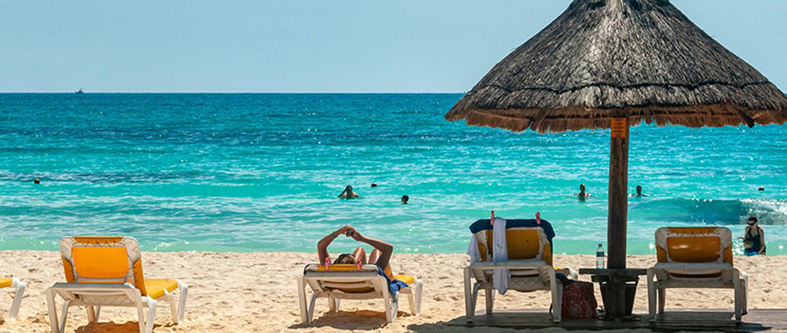 solstolar och ett parasoll på en strand