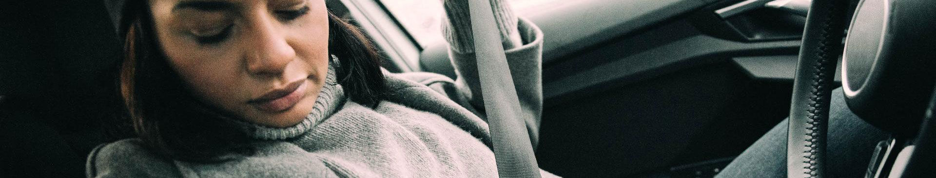 närbild kvinna som sätter på sig säkerhetsbälte