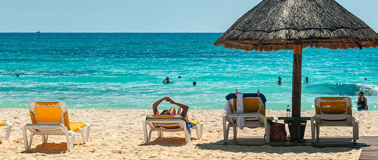 solstolar och parasoll på en strand