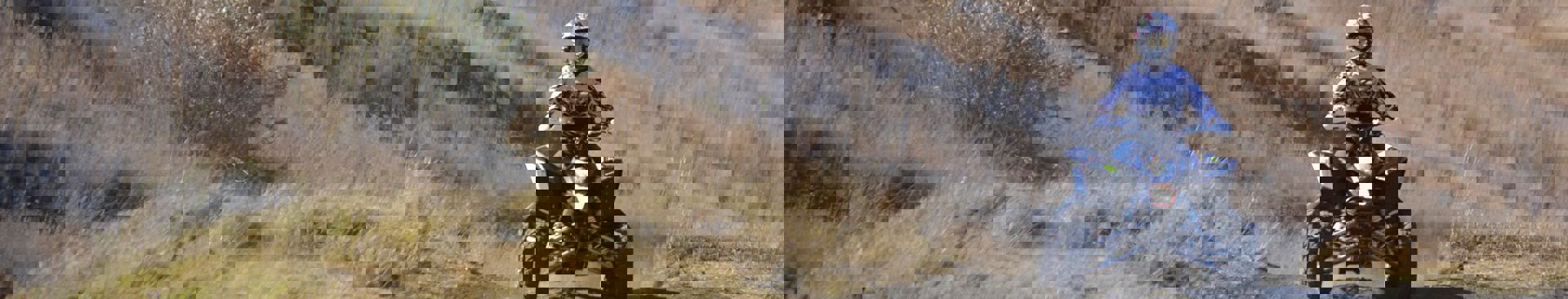 person som kör fyrhjuling ute i terräng