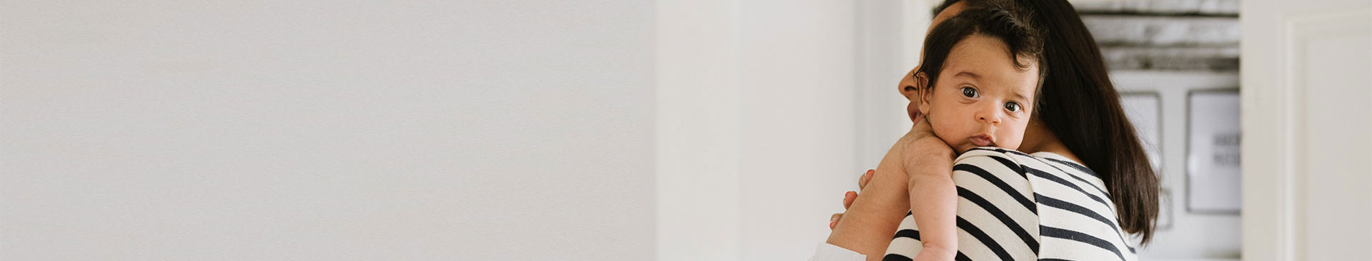 kvinna bär på sitt lilla barn